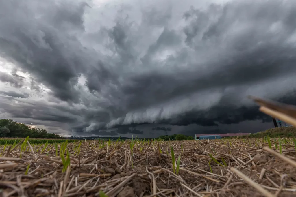 Supercellule orageuse – Nuages sombres sur champ agricole, photo dramatique de tempête Ciel d’orage avec nuages menaçants sur un champ cultivé au ras du sol