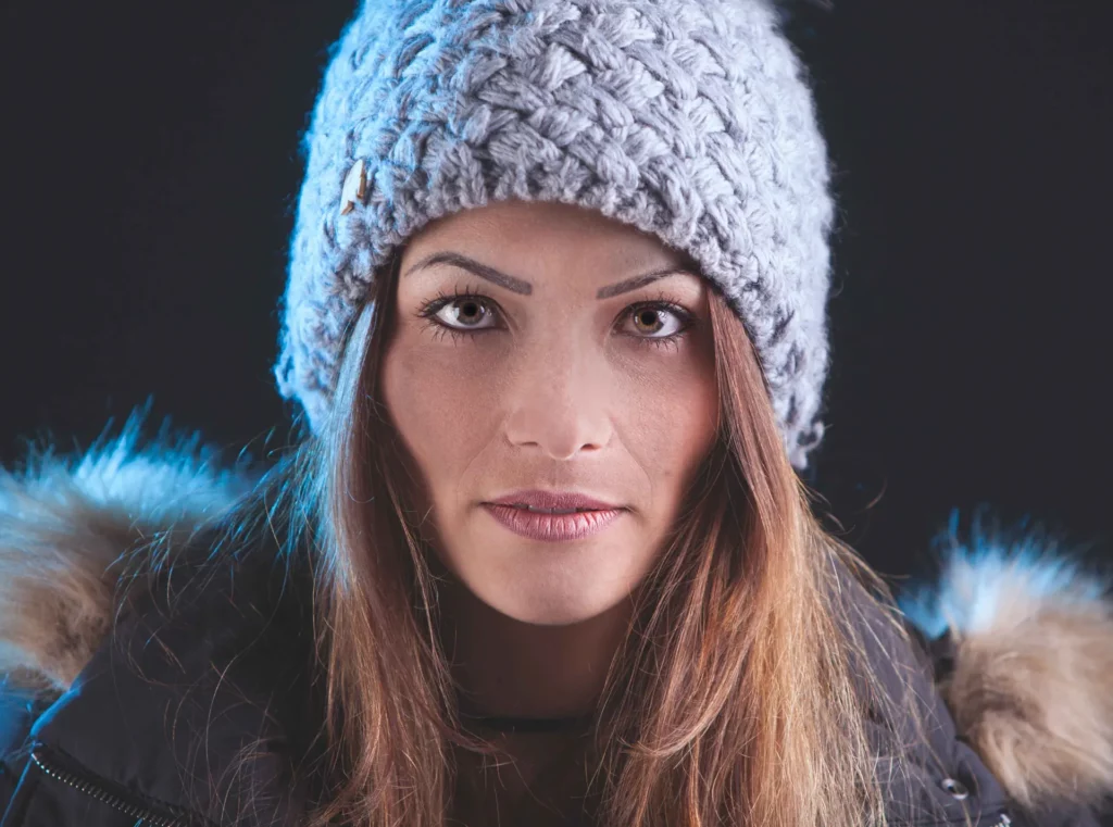 Portrait hivernal en studio – femme au bonnet gris – Tijoe, photographe à Mulhouse Portrait de femme en bonnet d’hiver, studio, lumière douce. Tijoe photographe Mulhouse