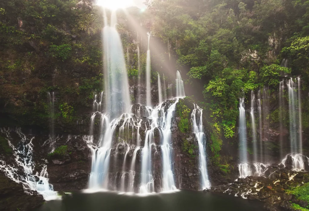 Cascade tropicale en forêt – Photo de paysage naturel en pose longue Cascade tropicale entourée de végétation luxuriante, photo nature prise en longue exposition
