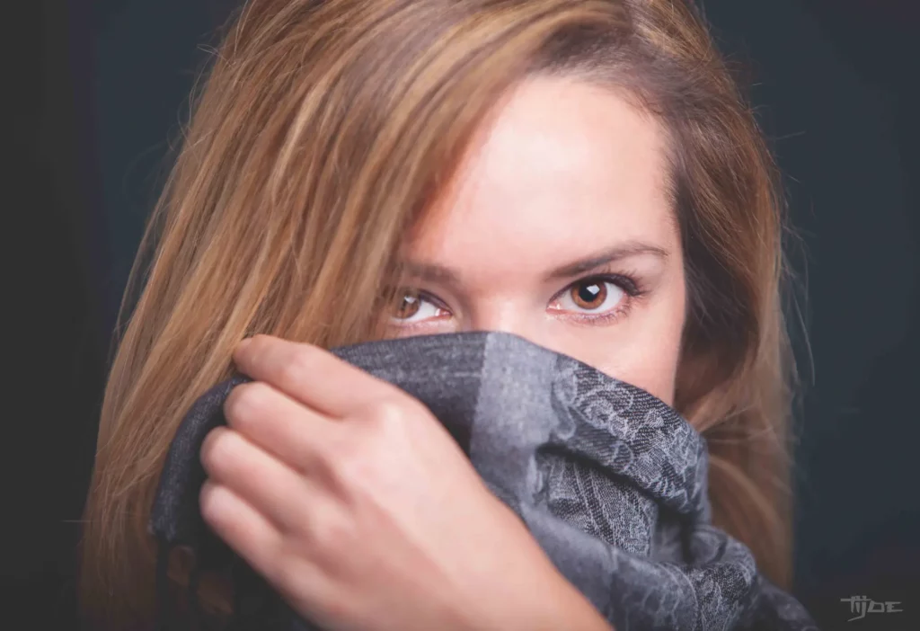 Portrait de femme en studio – regard captivant et ambiance douce Portrait artistique d'une femme aux yeux expressifs, photographie studio avec éclairage doux