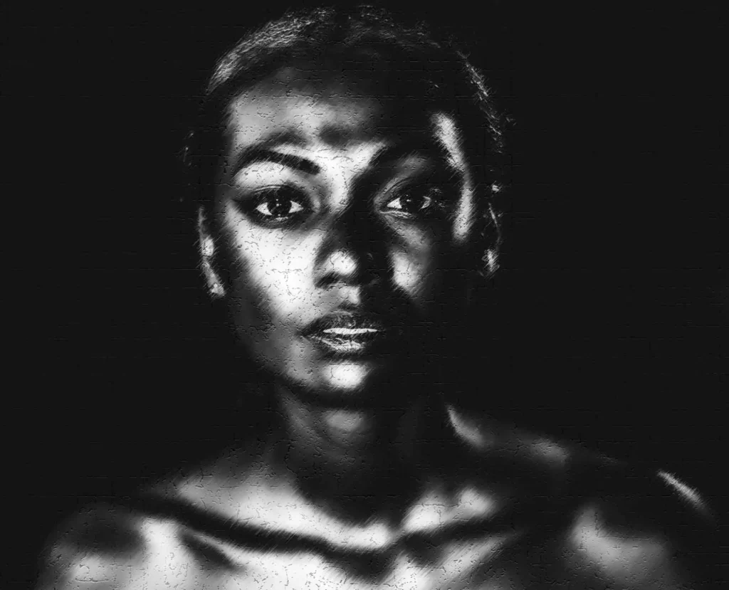 Portrait noir et blanc – Photographie de femme avec jeu de lumière Portrait artistique en noir et blanc d'une femme, ambiance dramatique et éclairage contrasté. Photographe Mulhouse