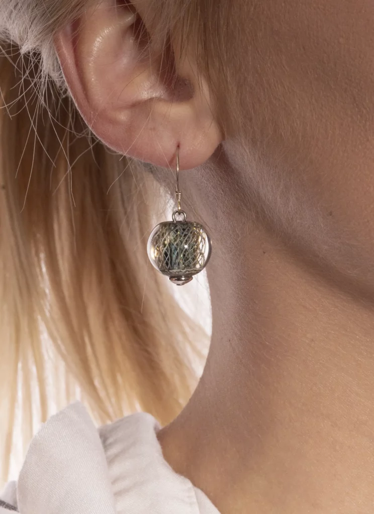 Photographie packshot de boucle d’oreille artisanale – Tijoe, photographe à Mulhouse Photographie packshot d’une boucle d’oreille artisanale portée, réalisée par Tijoe, photographe professionnel à Mulhouse.