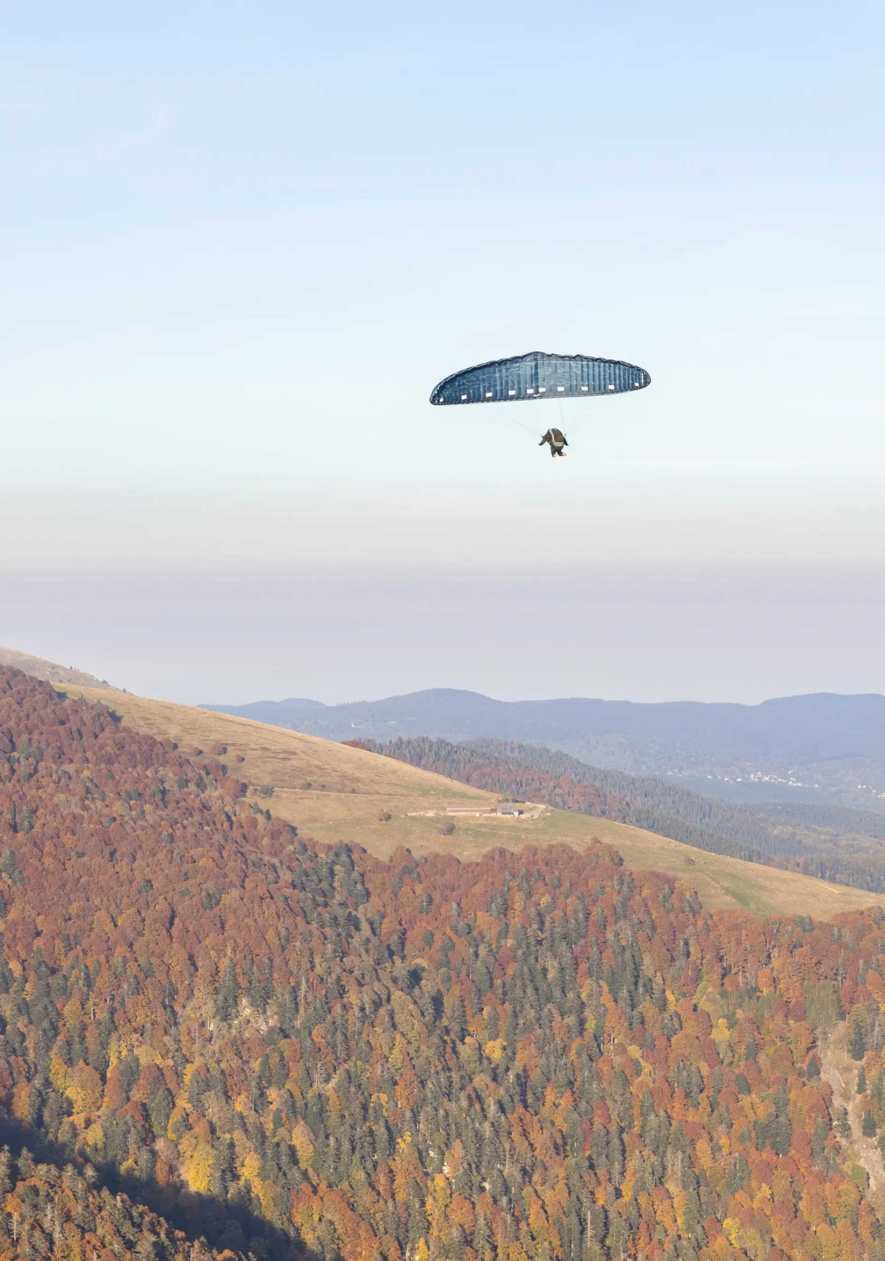 Photographe sport Mulhouse – Parapente d’automne dans les Vosges Photographie aérienne d’un parapentiste survolant les forêts d’automne des Vosges, par Tijoe Photographe sport à Mulhouse.