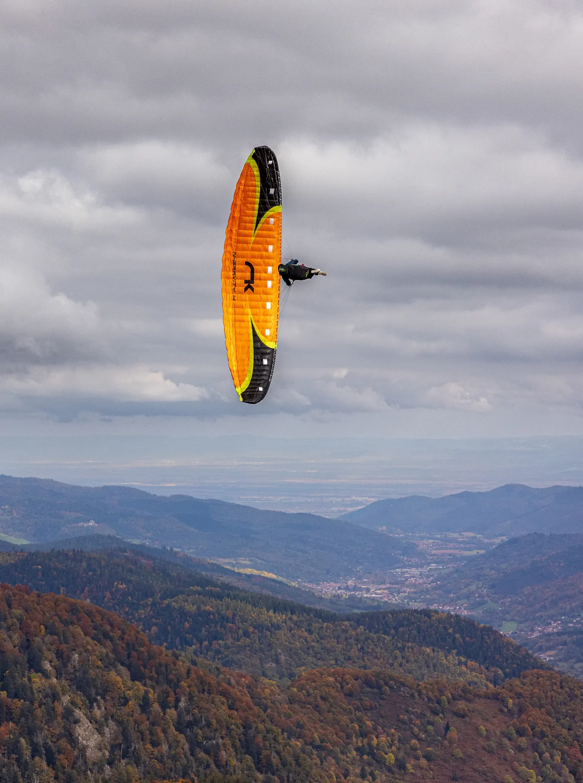 Photographe sport Mulhouse – Parapente en vol acrobatique Photographie d’un parapentiste en manœuvre aérienne au-dessus des Vosges, réalisée par Tijoe Photographe sport à Mulhouse.