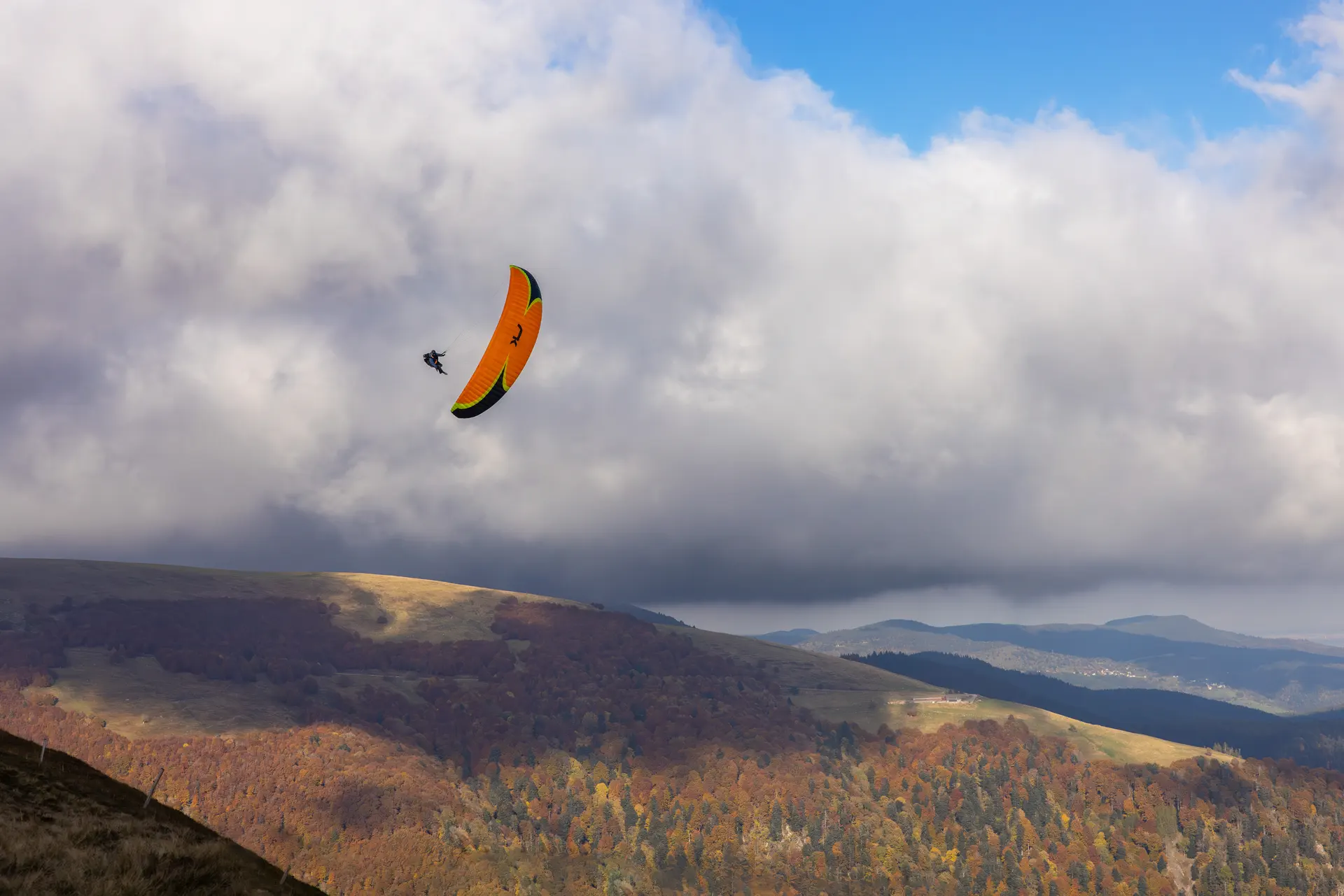Photographe sport Mulhouse – Parapente au-dessus des Vosges Parapentiste en vol au-dessus des montagnes vosgiennes, photo réalisée par Tijoe Photographe sport à Mulhouse.
