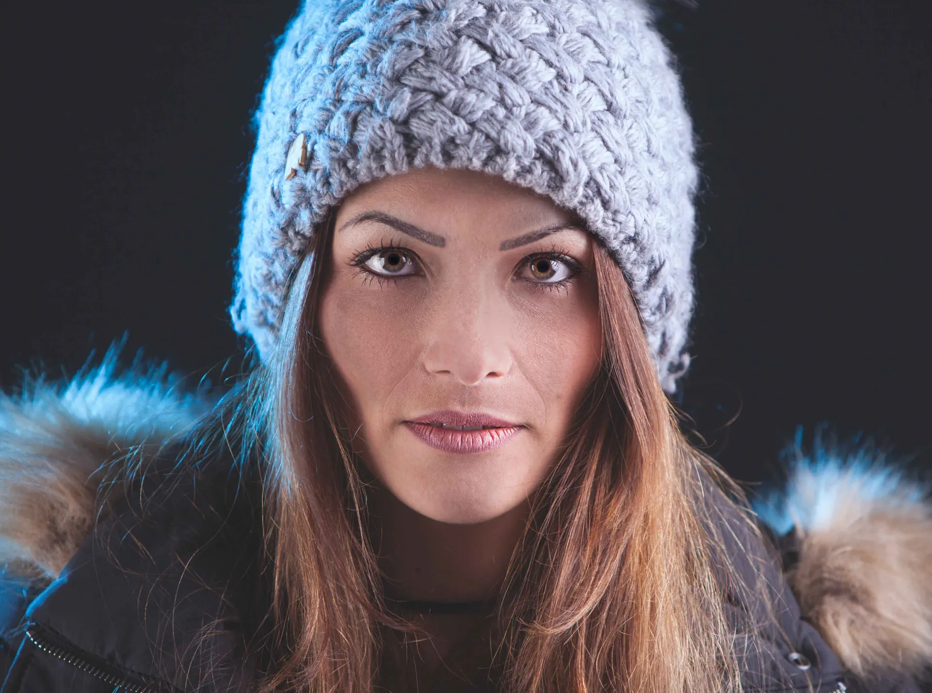 Portrait hivernal en studio – Tijoe photographe à Mulhouse Portrait d’une femme en bonnet et veste d’hiver, réalisé par Tijoe photographe à Mulhouse. Lumière douce et regard naturel en studio.