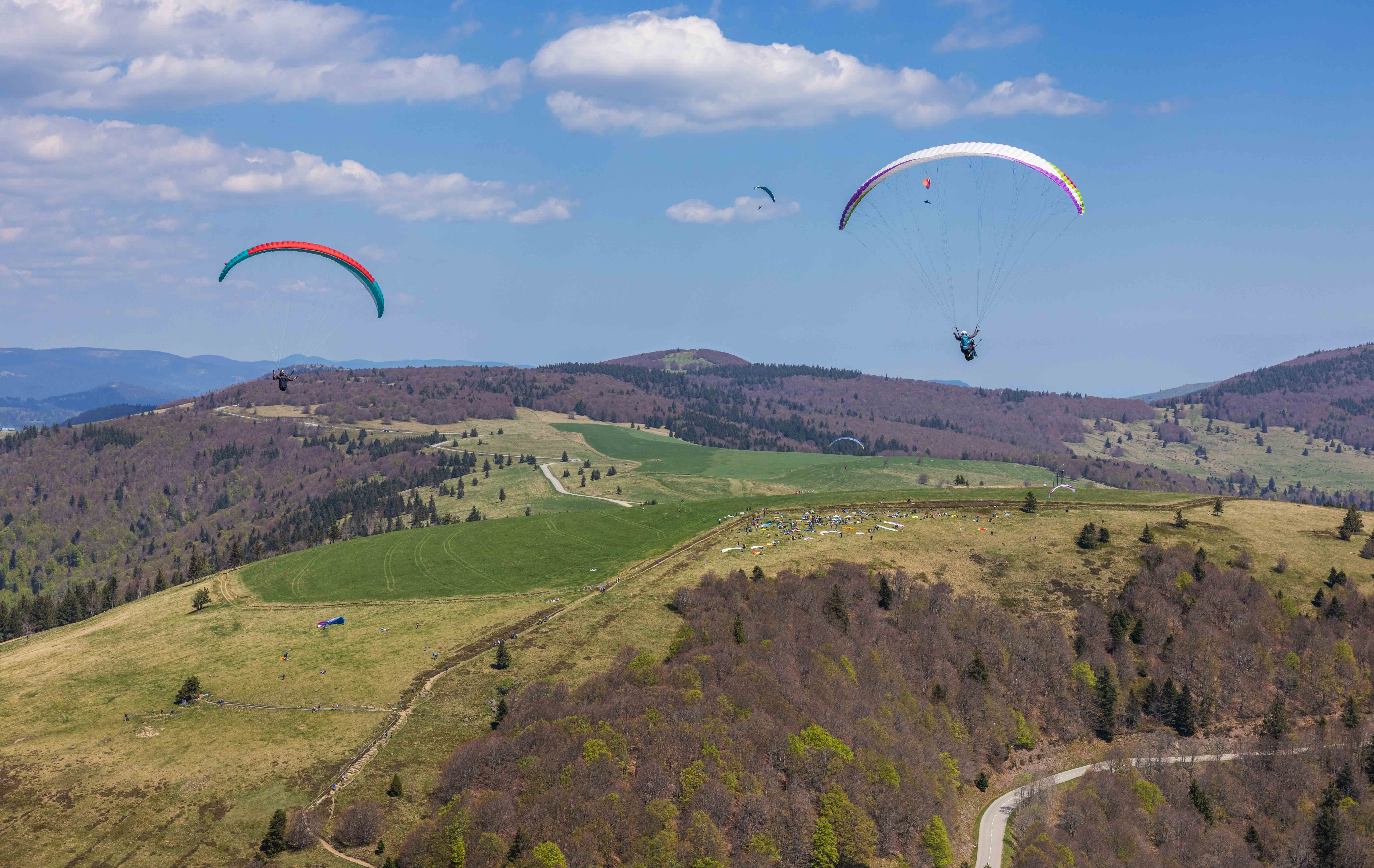 Parapentes en vol au-dessus des paysages vallonnés des Vosges – Photo signée Tijoe, photographe basé en Alsace