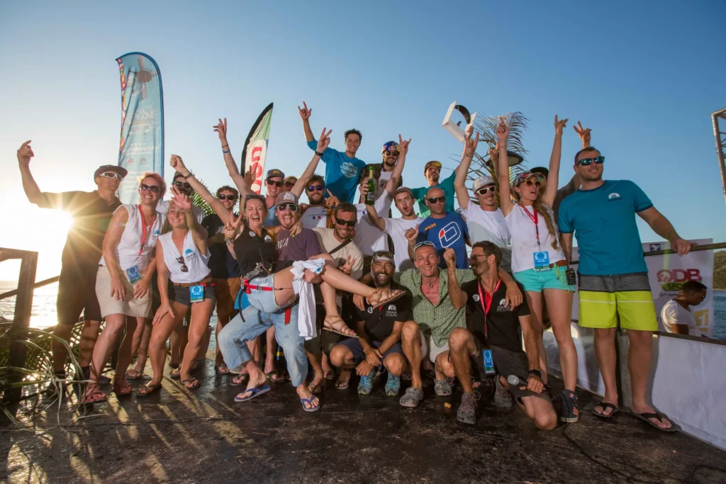 Groupe de participants en fête sur un podium au coucher du soleil, lors du Master Acro, sourires et trophées à la main