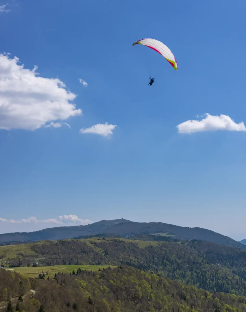 Parapente dans le ciel bleu au-dessus des montagnes vosgiennes – métaphore visuelle de l’élévation grâce à l’optimisation SEO Mulhouse