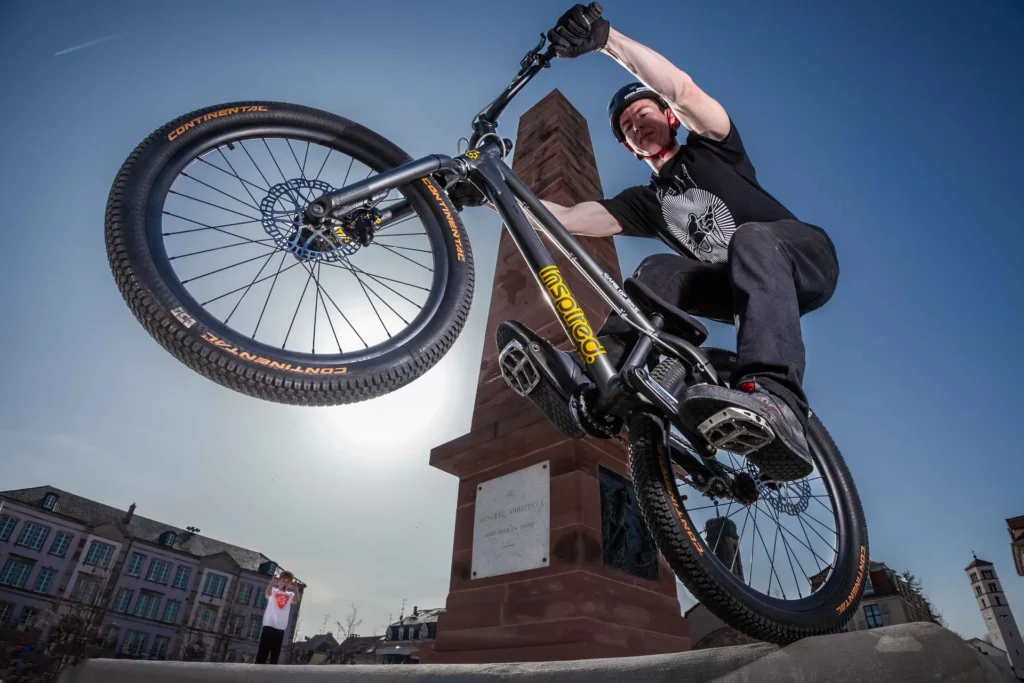 Rider en BMX trial réalisant une figure sur la place Abbatucci à Huningue