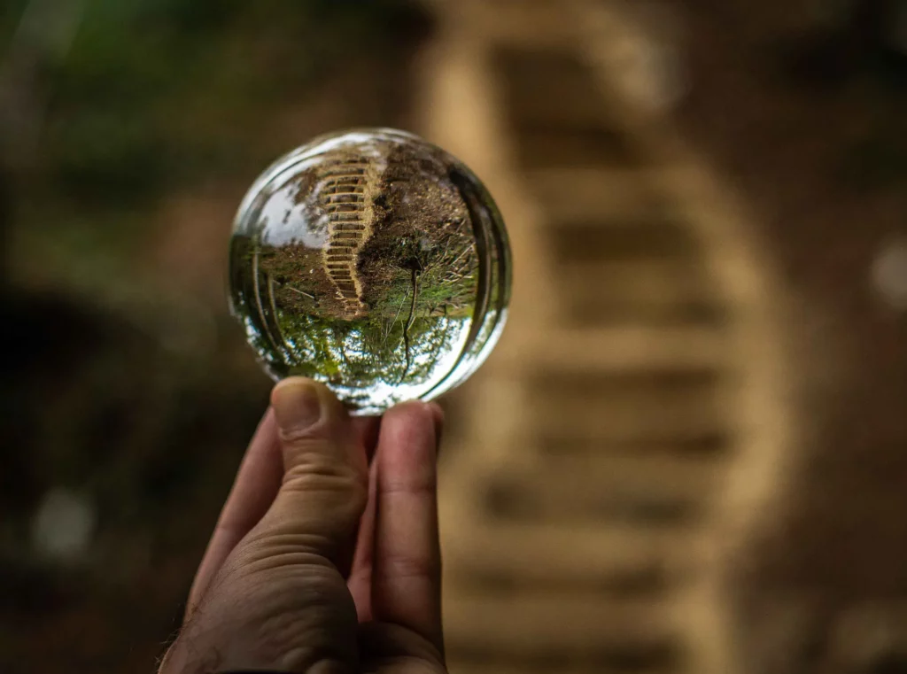 Escalier en forêt vu à travers une boule de cristal, effet de réfraction artistique